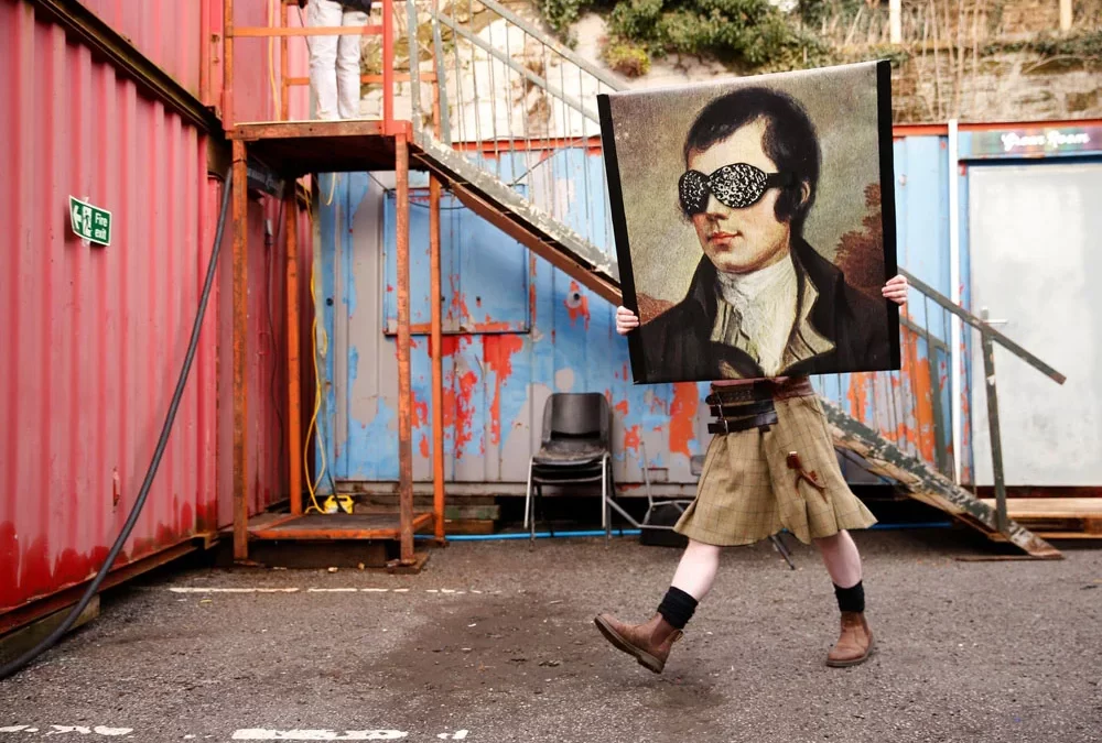 Person carrying a portrait of Rabbie Burns